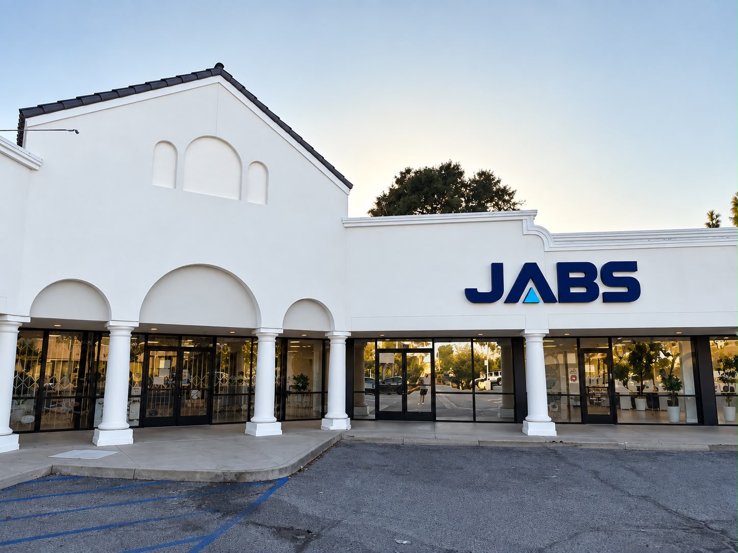 Exterior of the JABS ENTERPRISES INC. storefront in Pasadena, California, with the JABS sign above the glass entrance and parking in front
